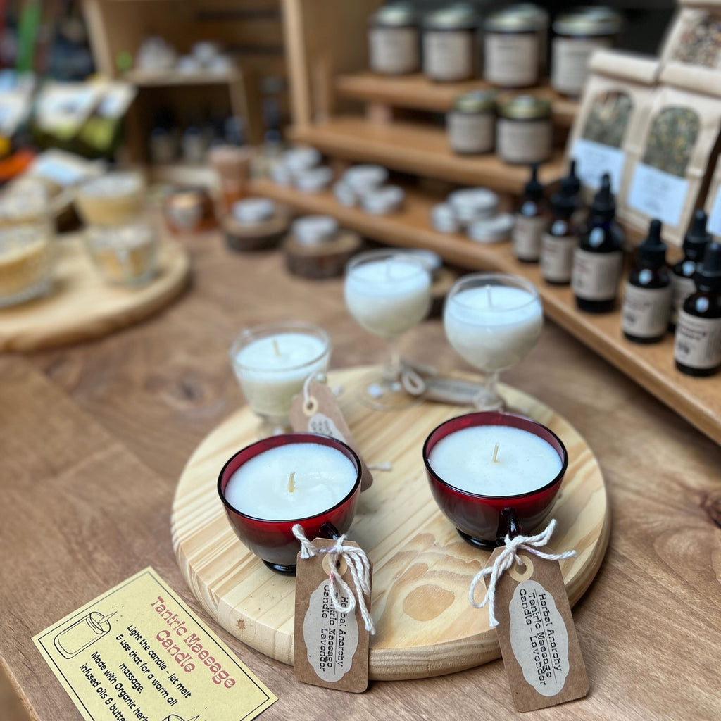 Handmade candles in cocktail glasses on a wooden table.